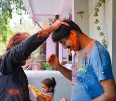 Delhi, Inde - février 26 2023 - Indien famille gens en jouant couleurs sur Holi festival, en portant différent couleurs, Holi Festival célébrations dans Delhi, Inde photo