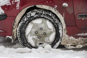 saleté neige plus de le voiture pneus sur le parking Extérieur. temps prévision, hiver conditions pour Conducteurs. photo