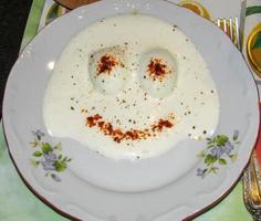 des œufs avec Mayonnaise sauce formé par une marrant visage sur une blanc plaque. le concept de nourriture photo