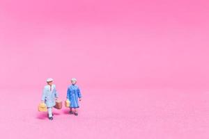 Couple miniature de voyageurs sur fond rose photo