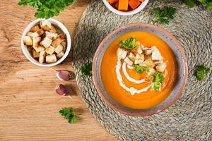 citrouille soupe dans une bol servi avec persil et Croûtons. végétalien soupe. action de grâces journée aliments. Halloween repas. Haut vue photo