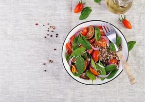 sarrasin salade avec Cerise tomates, rouge oignon et Frais épinard. végétalien aliments. régime menu. Haut voir. plat allonger photo