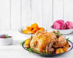 rôti dinde garni avec canneberges sur une rustique style table décoré l'automne feuille. action de grâces journée. cuit poulet. photo