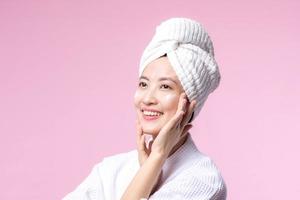 Jeune asiatique femme appliquant faciale soin de la peau visage crème, cosmétique Crème hydratante sur en bonne santé Naturel peau faire en haut affronter. portrait embrasé sourire fille la personne modèle avec se soucier beauté produit, spa, cosmétologie. photo