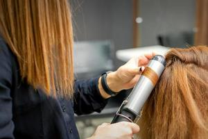 coiffeur fait du boucles avec curling le fer photo