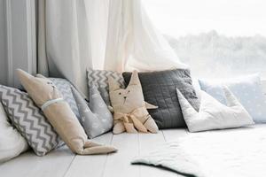 oreillers colorés pour enfants aux couleurs pastel. oreillers en forme de lapin et d'ours sur le lit dans la chambre des enfants photo