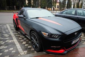 noir et rouge gué mustang avec 777 Licence assiettes sur rue. photo