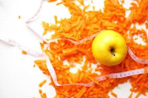 haché carottes et Pomme sur une blanc Contexte. des fruits et des légumes en bonne santé nourriture pour régime photo