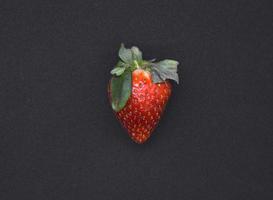 délicieux grand rouge des fraises sur une noir Contexte. rouge baie. baie victoria. photo