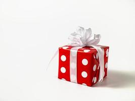 surprise cadeau pour Nouveau année, Noël, anniversaire, bien-aimé. rouge polka point boîte avec gros arc sur blanc Contexte.