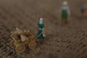 miniature Les figures de Les agriculteurs travail sur jute sacs. concept de agriculture photo. photo