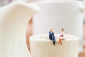 hommes d & # 39; affaires miniatures assis sur une tasse de thé photo