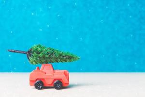 Sapin de Noël sur une voiture miniature, concept de célébration de la saison de Noël photo
