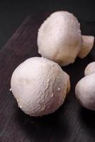 Frais brut champignon champignons sur une en bois Coupe planche avec épices