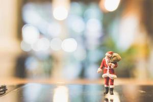 Père Noël miniature debout sur verre avec un arrière-plan flou photo