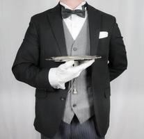 portrait de majordome ou serveur dans foncé formel costume en portant argent plateau. concept de un service industrie et professionnel hospitalité. photo