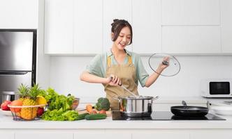 portrait de une femme au foyer dans le cuisine à Accueil photo