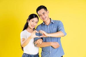 image d'un couple asiatique posant sur fond jaune photo