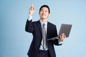 Portrait d'un homme d'affaires asiatique portant un costume sur fond bleu photo