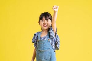 portrait d'une belle fille asiatique, isolée sur fond jaune photo