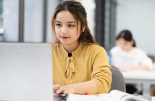 portrait de asiatique femelle étudiant en train d'étudier à Université bibliothèque photo