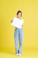 image de une jolie asiatique fille en portant une blanc panneau d'affichage photo