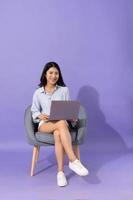 image de fille séance sur canapé isolé sur violet Contexte photo