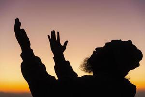 silhouette de homme a genou vers le bas prier pour culte Dieu à ciel Contexte. les chrétiens prier à Jésus Christ pour calme. dans Matin gens eu à une silencieux endroit et prié. copie espace. photo