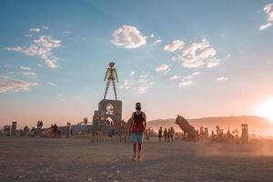 gens en marchant vers le coucher du soleil à une Festival dans le désert à le brûlant homme festival. photo