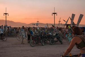 gens en marchant vers le coucher du soleil à une Festival dans le désert à le brûlant homme festival. photo