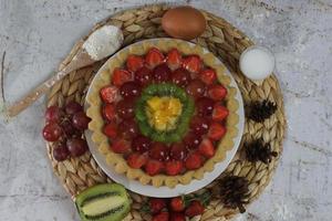 gros fruit tarte avec garnitures de des fraises, raisins, kiwi et ananas. sarriette, sucré et frais. nourriture concept photo. photo