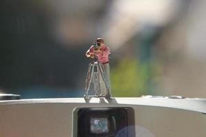 miniature figure de une vidéaste enregistrement sur un analogique caméra. photo