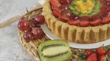 gros fruit tarte avec garnitures de des fraises, raisins, kiwi et ananas. sarriette, sucré et frais. nourriture concept photo. photo