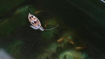 miniature figure de une pêcheur pêche sur une Lac dans une petit bateau. photo