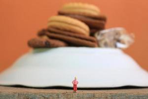 miniature figure de une enfant à la recherche en haut à le montagnes fabriqué de une assiette et certains Gâteaux. photo