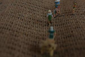 miniature Les figures de Les agriculteurs travail sur jute sacs. concept de agriculture photo. photo