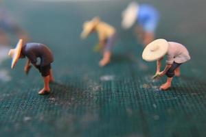 miniature Les figures de Les agriculteurs travail sur une Coupe tapis. concept de agriculture photo. photo