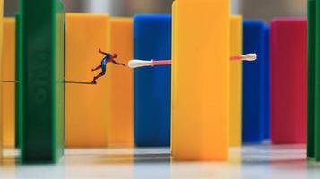 une miniature Humain figure avec le Puissance de une araignée sauter plus de une coloré bloquer jouet. leur concept de réinventer super-héros. photo
