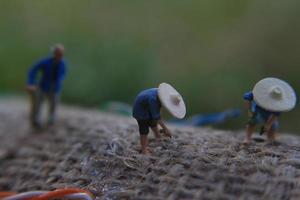 photo de une miniature figure avec le concept de une agriculteur agriculture sur une toile de jute sac