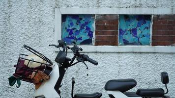 un électronique bicyclette arrêté près le mur de le vieux bâtiment dans le ville photo