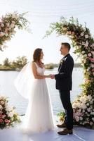 cérémonie de mariage sur une haute jetée près de la rivière photo