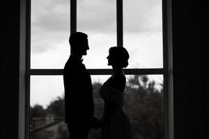 jeune marié dans une noir costume attacher et le la mariée dans une brillant studio photo