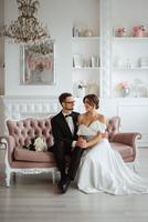 jeune marié dans une noir costume attacher et le la mariée dans une brillant studio photo