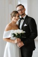 jeune marié dans une noir costume attacher et le la mariée dans une brillant studio photo