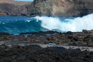 grand vagues s'écraser contre le rochers dans le océan photo