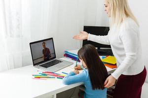 mère et fille dans protecteur masque faire devoirs à distance Accueil scolarité, quarantaine photo