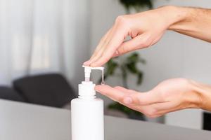 homme mains en utilisant laver main désinfectant gel distributeur, contre roman coronavirus ou couronne virus maladie à Publique train gare. antiseptique, hygiène et soins de santé concept photo