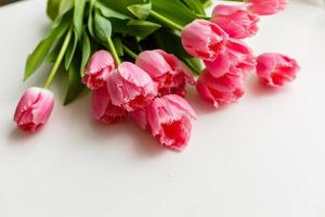 rose tulipes mensonge sur une blanc table photo