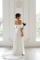 brunette la mariée dans une serré mariage robe dans une brillant studio photo