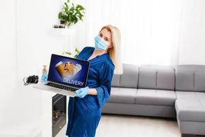 commande nourriture et médicament dans un en ligne boutique pendant le quarantaine et épidémie, portrait de une femme dans une médical masque photo